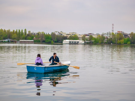 Bucharest, Romania - 04.15.2022: Many people in boats paddling on the lake in King Mihai I park (Herestrau). Couple on a romantic gateaway.のeditorial素材