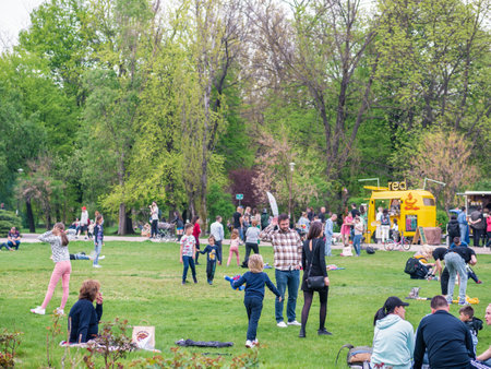 Bucharest, Romania - 04.15.2022: People relaxing and having fun on the grass in KIng MIhai I park (Herestrau), in Bucharestのeditorial素材