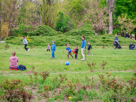 Bucharest, Romania - 04.15.2022: People relaxing and having fun on the grass in KIng MIhai I park (Herestrau), in Bucharestのeditorial素材