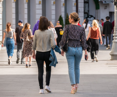 Bucharest, Romania - April 2022: Two young attractive women walking or strolling on the sidewalk in the old town center Bucharest, Romania.のeditorial素材