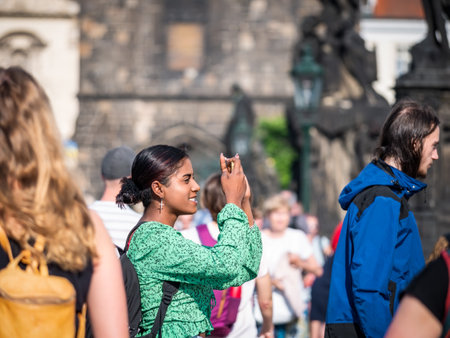 Prague, Czech Republic - June 2022: Happy smilling tourists strolling and taking pictures on the famous Charles Bridge in Prague.のeditorial素材