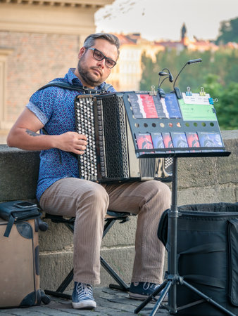 Prague, Czech Republic - June 2022: Street artist musician playing at an Accordion on Charles Bridge, Pragueのeditorial素材