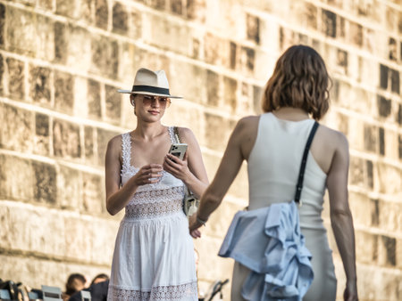 Prague, Czech Republic - June 2022: Tourists attractive girl wearing a hat strolling along the Vltava river, in Pragueのeditorial素材