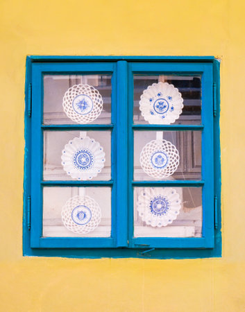 Ornamental traditional plates or dish on display in a old wooden window. Golden lane in Prague, Czech Republic.の写真素材