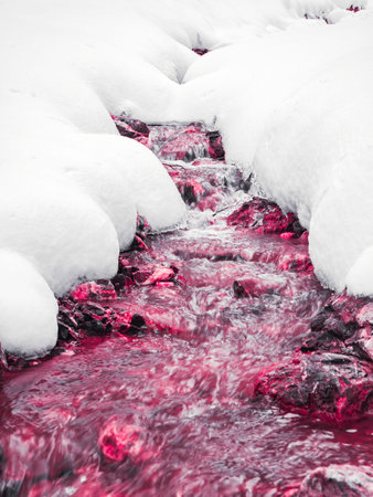 Abstract minimalist picture of a red blood stream flowing beneath the frozen snow