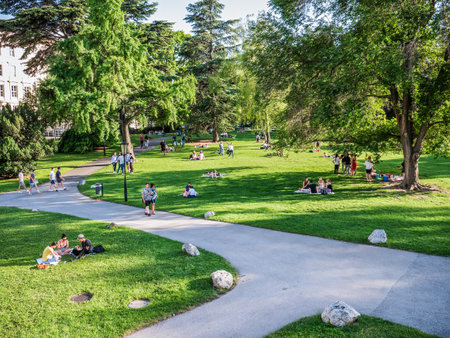 Vienna, Austria - June 2022: People, tourists and locals relaxing and having fun on the green grass in Burggarten park in Vienna.のeditorial素材
