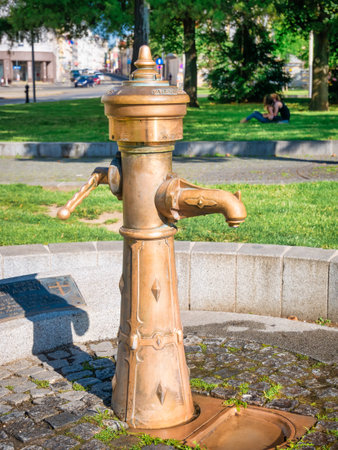 Outdoor water tap. Close up with a bronze vintage faucet in a park, locate in Vienna, Austriaの写真素材