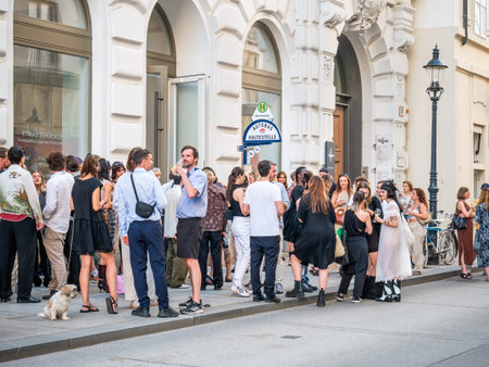 Vienna, Austria - June 2022: Many young people hanging out on the sidewalk in front of a club in the...