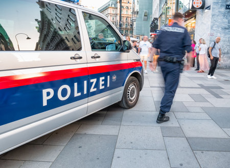 Vienna, Austria - June 2022: Police car and officer patrolling in the center of Viennaのeditorial素材