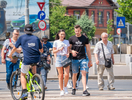 Bucharest, Romania - June 2022: Many pedestrian people and on bicycles crossing the street on zebra crossing in Bucharest.のeditorial素材