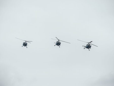 Three helicopters flying against a cloudy sky. Airshow demonstration.