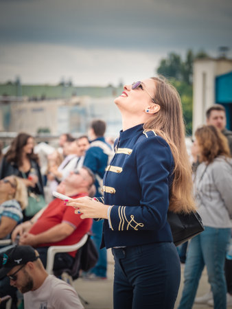 Bucharest, Romania -September 2022: Group of people at an airshow looking up into the sky. Attractive girl in uniformのeditorial素材