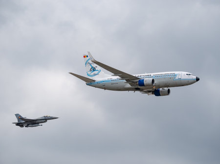 Bucharest, Romania -September 2022: A Boeing 737-78J with Tarom Happy 66 years Livery flying at an airshow. Airplane escorted by a F-16 Fighting Falcon aircraft.のeditorial素材