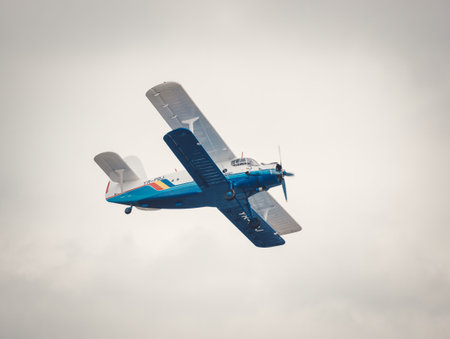 Bucharest, Romania - September 2022: A soviet Antonov An-2 single-engine biplane flying against blue sky.のeditorial素材