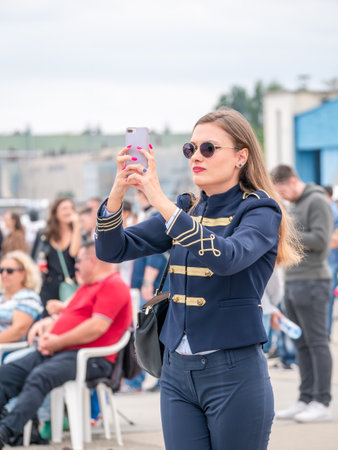Bucharest, Romania -September 2022: Attractive young girl taking a picture with the smartphone. Happy smiling womanのeditorial素材