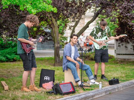 Bucharest, Romania - July 2022: Band of young street artists with a guitar playing and singing in the center of Bucharest.のeditorial素材