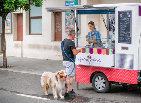 Bucharest, Romania - August 2022: Man with a dog pet buying ice cream from a mobile truck street vendor in the center of Bucharest.のeditorial素材