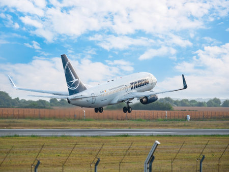 Bucharest, Romania - August 2022: A TAROM BOEING 737-700 airplane flying against clear blue sky. Airplane takes off from Henry Coanda International Airport.のeditorial素材