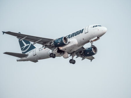 Bucharest, Romania - August 2022: TAROM Airbus A318 airplane flying against the sky at sunset. Airplane takes off from Henri Coanda International Airport.のeditorial素材