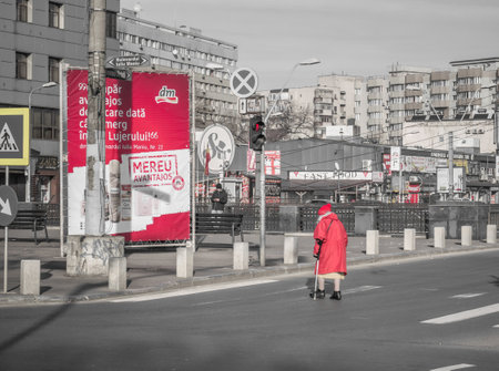 Bucharest, Romania - 01.01.2023: Senior woman slowly crossing the street in Bucharest.のeditorial素材