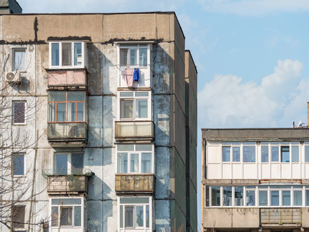 Worn out apartment building from the communist era against blue sky in Bucharest Romania. Ugly traditional communist housing ensembleの写真素材