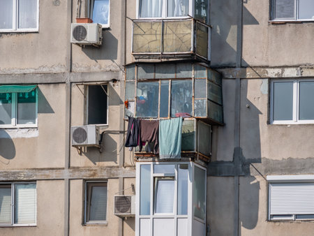 Worn out apartment building from the communist era against blue sky in Bucharest Romania. Ugly traditional communist housing ensembleの写真素材