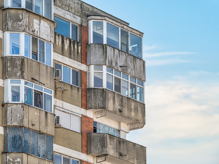 Worn out apartment building from the communist era against blue sky in Bucharest Romania. Ugly traditional communist housing ensembleの写真素材