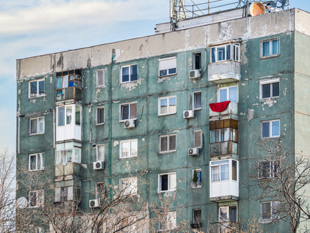 Worn out apartment building from the communist era against blue sky in Bucharest Romania. Ugly traditional communist housing ensembleの写真素材