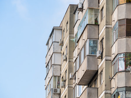 Worn out apartment building from the communist era against blue sky in Bucharest Romania. Ugly traditional communist housing ensembleの写真素材