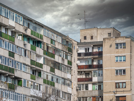 Worn out apartment building from the communist era against blue sky in Bucharest Romania. Ugly traditional communist housing ensembleの写真素材