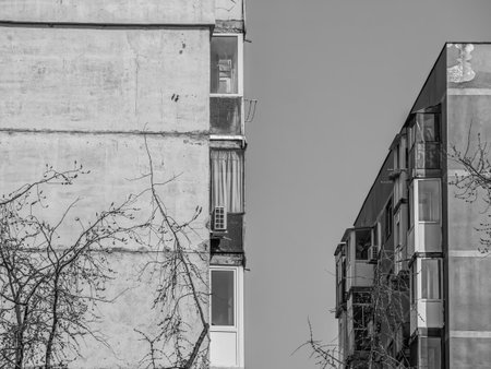 Worn out apartment building from the communist era against blue sky in Bucharest Romania. Ugly traditional communist housing ensemble. Black and white abstract photography.の写真素材