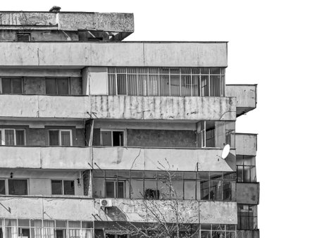 Worn out apartment building from the communist era against blue sky in Bucharest Romania. Ugly traditional communist housing ensemble. Black and white abstract photography.の写真素材