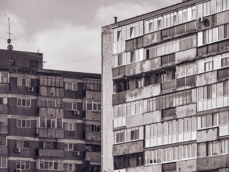 Worn out apartment building from the communist era against blue sky in Bucharest Romania. Ugly traditional communist housing ensembleの写真素材