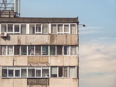 Worn out apartment building from the communist era against blue sky in Bucharest Romania. Ugly traditional communist housing ensembleの写真素材
