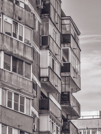 Worn out apartment building from the communist era against blue sky in Bucharest Romania. Ugly traditional communist housing ensembleの写真素材
