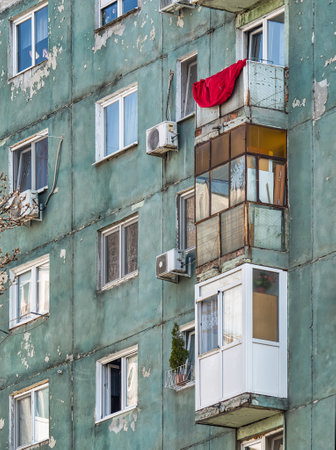 Worn out apartment building from the communist era against blue sky in Bucharest Romania. Ugly traditional communist housing ensembleの写真素材
