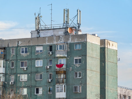 Worn out apartment building from the communist era against blue sky in Bucharest Romania. Ugly traditional communist housing ensembleの写真素材