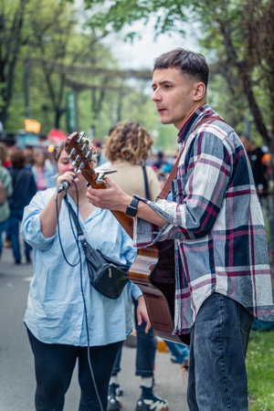 Bucharest, Romania - August 2022: Young street artist with a acoustic guitar playing in the center of Bucharest (Victory street - Calea Victoriei).のeditorial素材