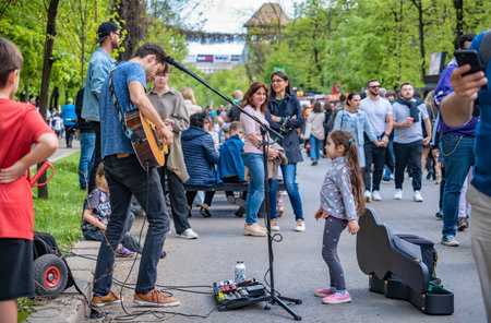 Bucharest, Romania - August 2022: Young street artist with a acoustic guitar playing in the center of Bucharest (Victory street - Calea Victoriei).のeditorial素材