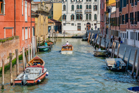 Picturesque Scene from Venice with stone bridges over the water canals and the boat traffic.のeditorial素材