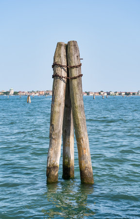 Vertical thick wooden posts called bricole (Venice bricola) on the Grand Canal in Veniceの写真素材