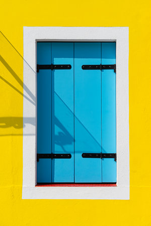 Detail with a colorful house window with blue painted wooden shutters in Burano, Italy.の写真素材