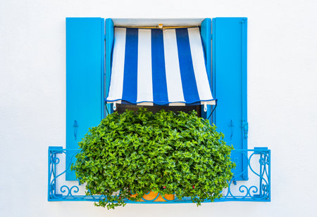Detail with a house window with blue painted wooden shutters in Burano, Italy.の写真素材