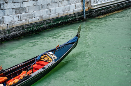 Close up with a traditional gondola boat ride on the water canal in Venice, Italyの写真素材