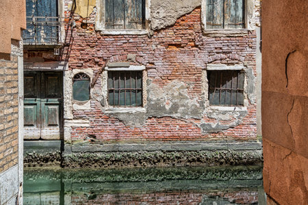 Old medieval worn out brick wall building in Venice, Italy.の写真素材
