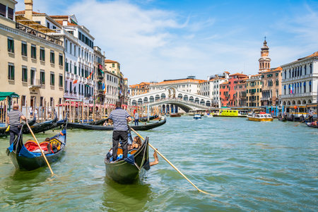 Venice, Italy - May 30 2023: Traditional gondola ride on the Grand Canal near Rialto Bridge (Ponte di Rialto). Tourists in Venice.のeditorial素材