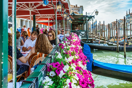 Venice, Italy - May 30 2023: Outdoor cafe restaurant with view over the Grand Canal in Venice. Tourists relaxing and having lunch.のeditorial素材