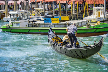 Venice, Italy - May 30 2023: Traditional gondola ride on the Grand Canal near Rialto Bridge (Ponte di Rialto). Tourists in Venice.のeditorial素材