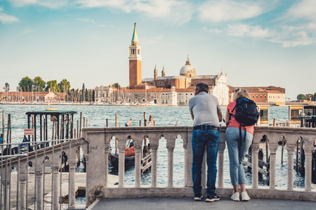 Venice, Italy - May 30 2023: Tourist couple enjoying the idyllic scene on Grand Canal in Venice.のeditorial素材