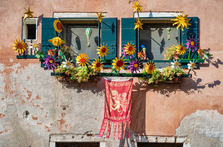 Old venetian window with flower decoration and Flag of the Republic of Venice. Close up detail.の写真素材